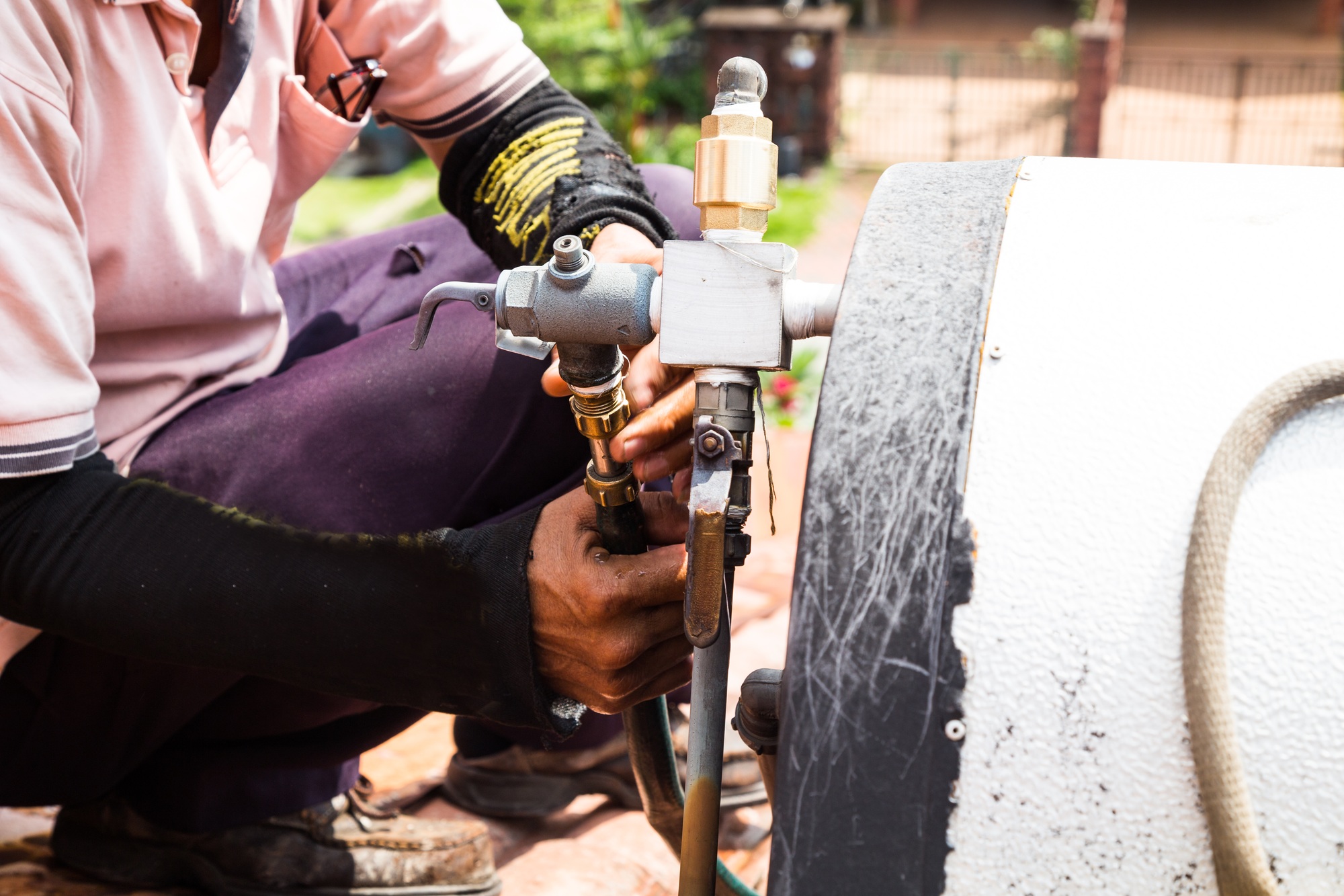 Closeup Worker fixing solar water heater on roof during maintena