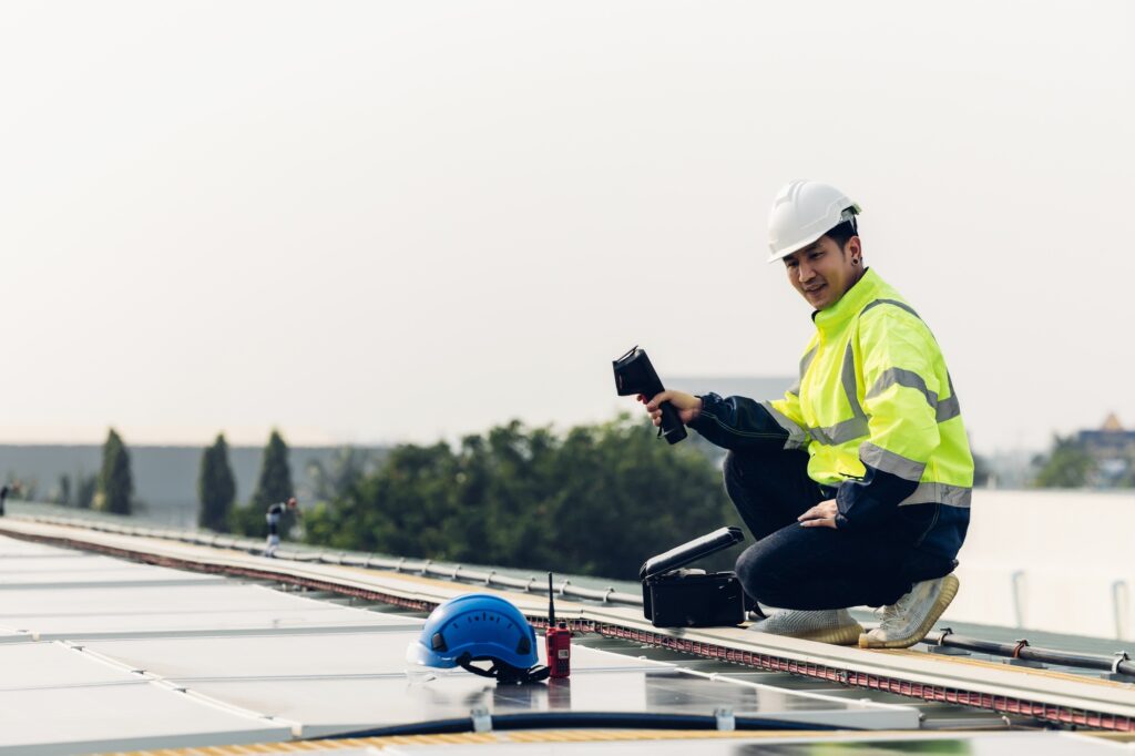 Inspector examination of photovoltaic modules using a thermal imaging camera.