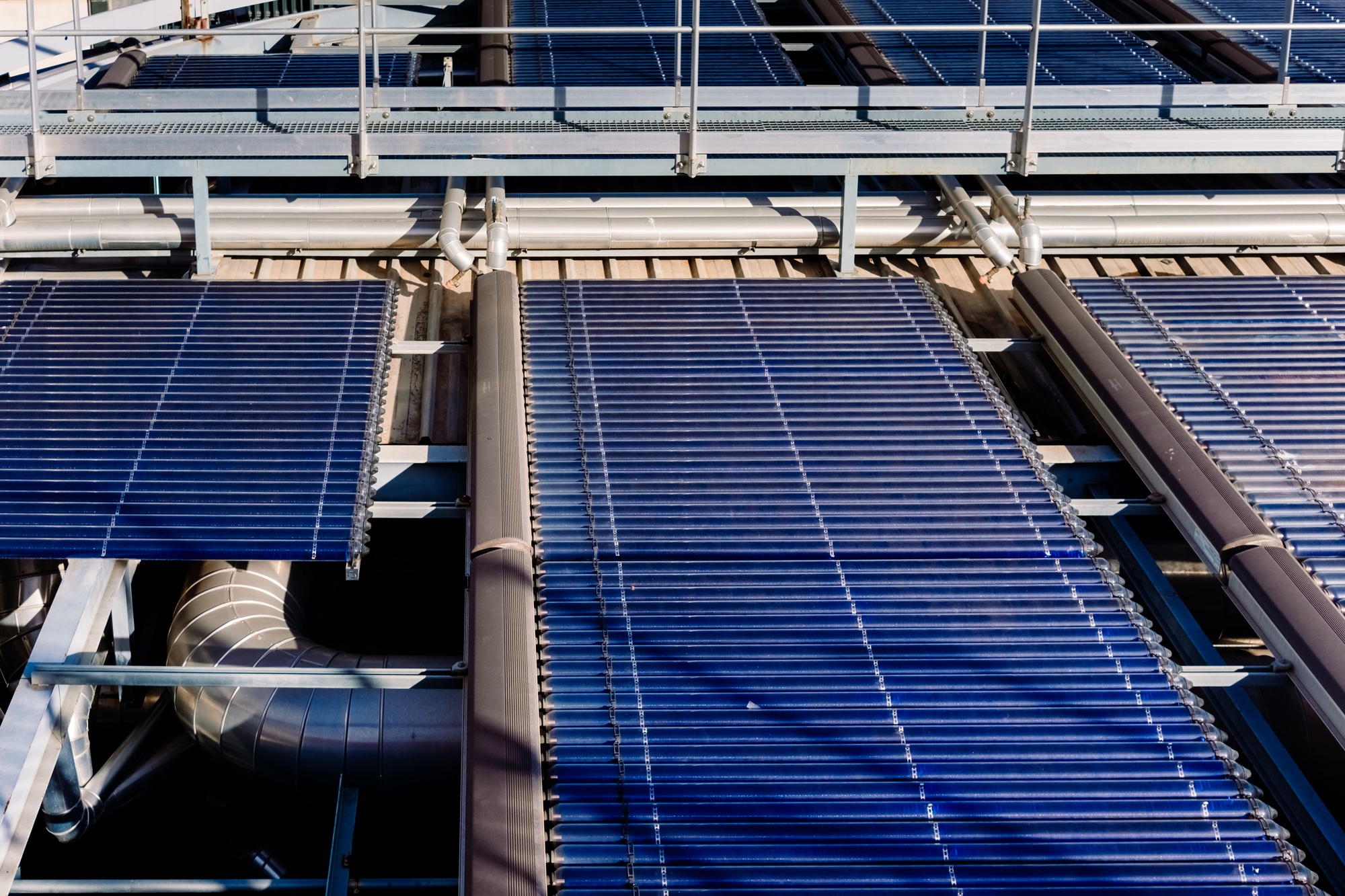 Installation on a roof of large solar thermal vacuum tube plates for heating.